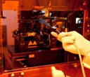 Photo of researcher loading a template used for nano-sculpting on plastic films.